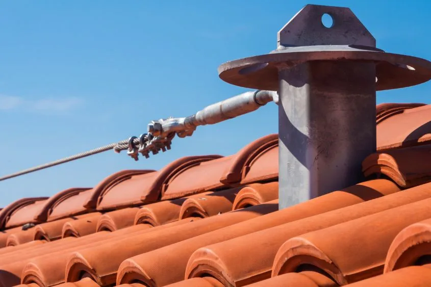 Metal roof vent pipe with sealing collar on an orange tile roof